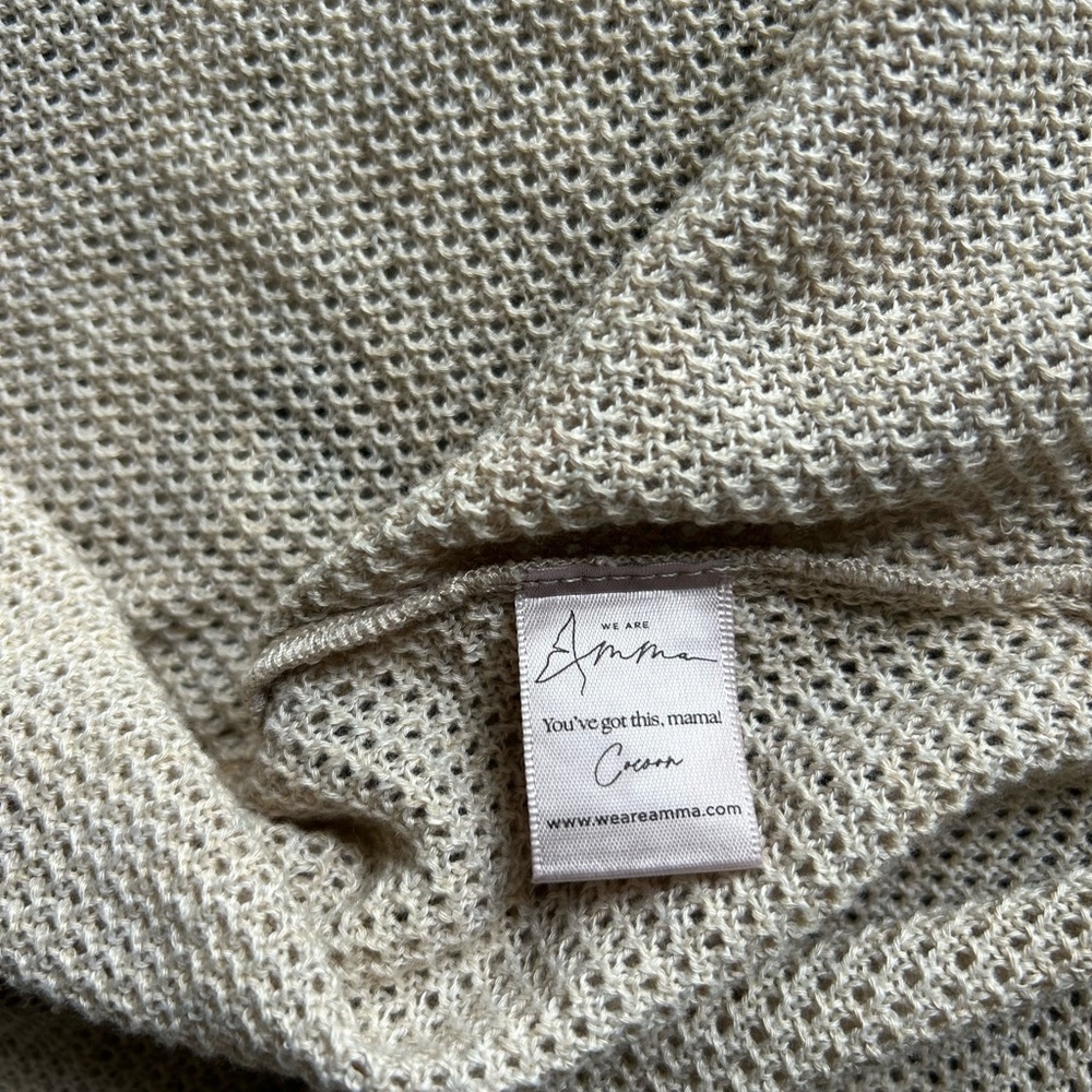 Amma nursing cover poncho, in a neutral cream/tan color.